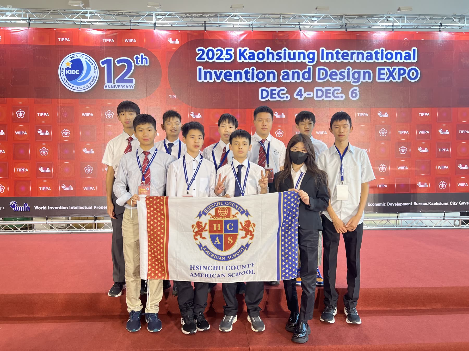The team holding the school flag, KIDE 2025